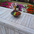 A rustic wooden bowl sits on top of a fabric fitted table cover covering a 6ft folding table during an outdoor event. The table cover looks like real wood.
