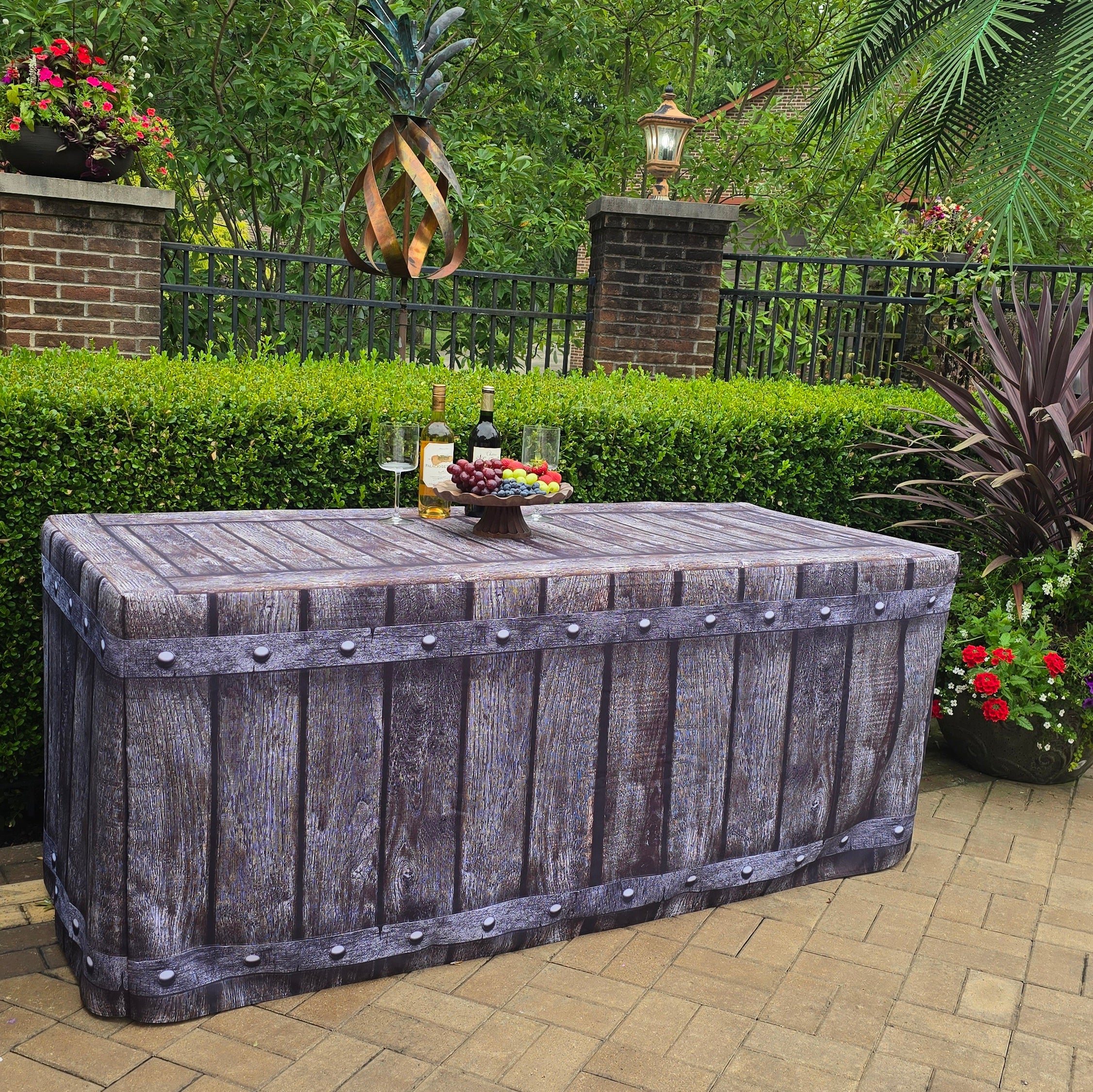 Outdoor special event or party decorated with a 6ft fabric table cover that looks like old reclaimed wood with metal rivets along the side of the table cover. 
