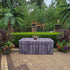 Fabric Fitted Table cover that looks like old reclaimed wood with metal rivets sitting along a row of boxwood bushes poolside at a resort.