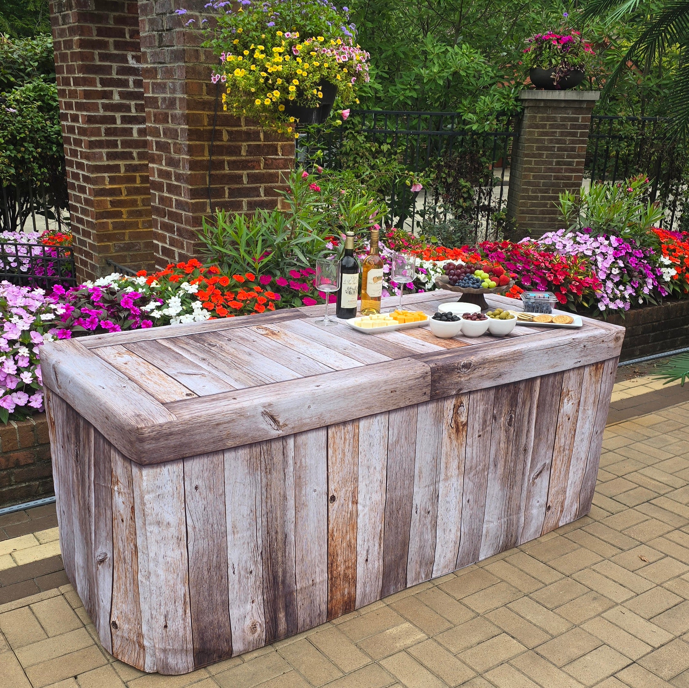 A Weathered Wood Polyester Fitted Table Cover over a plastic folding table  at a special event or wedding.