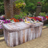 A Weathered Wood Polyester Fitted Table Cover over a plastic folding table  at a special event or wedding.