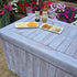 Folding table covered with a rustic white washed fabric fitted table cover that looks like wood for an outdoor casual catered event.